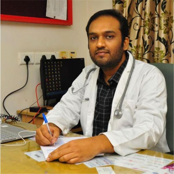 Dr. Abdul Basith is writing at his desk in his cabin.